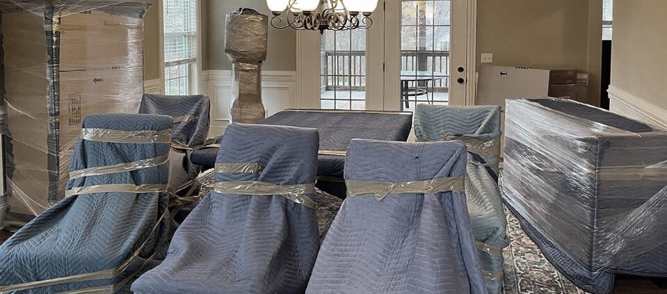 furniture wrapped in protective blankets and plastic for moving